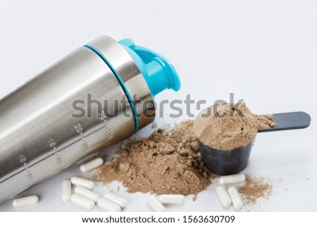 Fitness nutrition and supplements. Shaker, scoop with protein powder and pills.