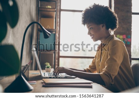 Profile side photo of smart cool afro american girl entrepreneur sit table use laptop work presentation in office loft workplace