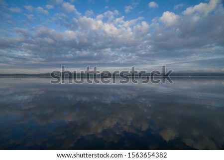Early morning sky with clouds reflected in the lake
