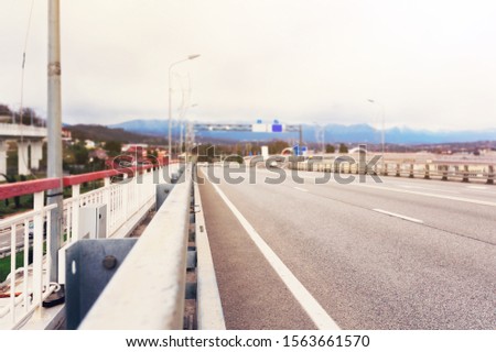 Highway overpass motion blur effect with modern city background.
