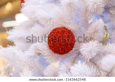Christmas tree with bauble ornaments. Decorated Christmas tree closeup. Balls and illuminated garland with flashlights. New Year baubles macro photo with bokeh. Winter holiday light decoration