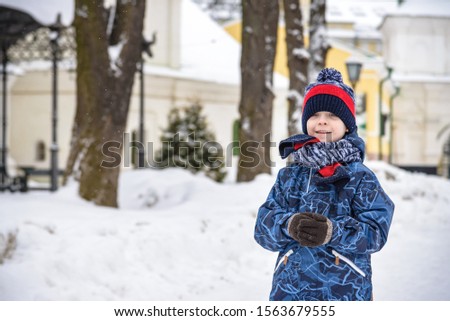 Little boy walking in the park. Child going for a walk after school with a school bag in winter. Children activity outdoors in fresh air. Healthy way of life concept.