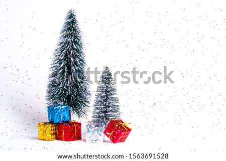 Presents and gifts box under Christmas fir tree. Winter Holiday. White snow background. 
