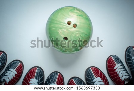 Indoor family sports. Many bowling shoes and bowling ball on white background. Top view. Minimalism