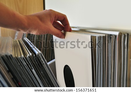 Browsing through vinyl records collection. Music background.