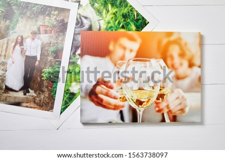 Wedding photo printed on canvas. Sample of stretched photography. Canvas prints on white wooden background, top view