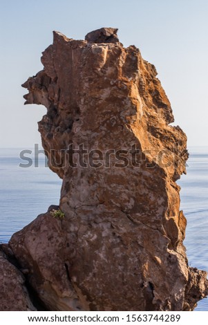 Big rock standing with sea on the background 
