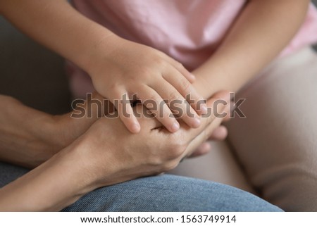 Close up cropped image little daughter putting hand on mommy s hands, demonstrating support and care. Young caring woman joined palms with small kid girl. Symbol of love and family understanding. Royalty-Free Stock Photo #1563749914