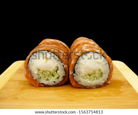 Philadelphia roll with cheese on wooden Board plate on dark background