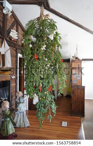 Up side down, Christmas tree, hanging from the ceiling with rope, with simple rural decorations, Bavarian style restaurant, Eastern Shore Winter Festival, Nova Scotia, Canada Royalty-Free Stock Photo #1563758854