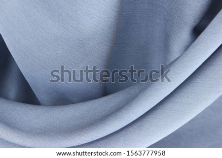 Gray natural silk is draped with soft pleats, background