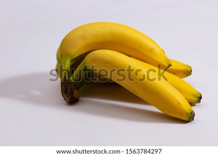 Branch of ripe yellow bananas close-up on a white background