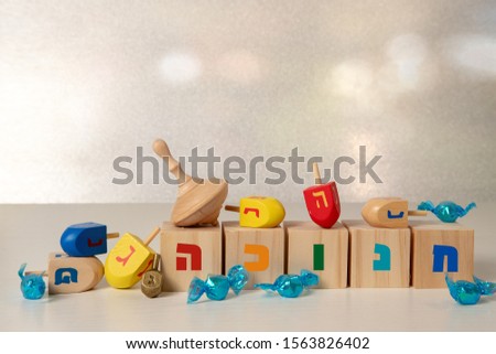 concept of of jewish religious holiday hanukkah with wooden spinning top toy (dreidel) and chocolate coins