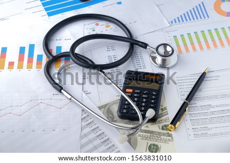 Stethoscope with Pen, Charts, Graphs, Finance, Account, Statistics, Investment, Analytic Research Data, Medical and Insurances Concept