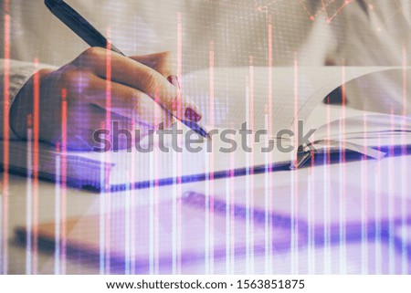 Double exposure of woman's hands making notes with forex graph hologram. Concept stock market analysis.