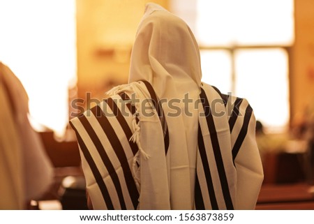 Orthodox ultra Orthodox Jew from a tallit in the synagogue. rear view of an orthodox Jew in the mantle, a bit in the synagogue Royalty-Free Stock Photo #1563873859
