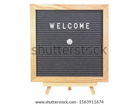 Simple welcome message text word  on a quare shaped old style letter board with grey felt background and light colour wooden frame isolated on white with smiling star in white characters