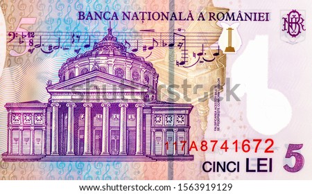 "Romanian Athenaeum" concert hall in Bucharest; A fragment of musical chord (notes, score, notation) from Enescu's opera "King Oedipus" Portrait from Romania 5 Lei 2005 Banknotes. Royalty-Free Stock Photo #1563919129