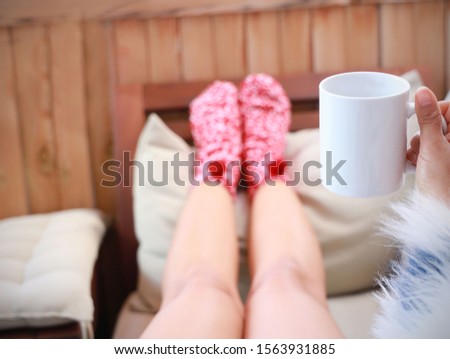 Young woman holding legs on coffee table and  Close up on feet,Winter and Christmas holidays concept.
