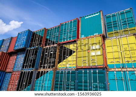 The national flag of  Bahames on a large number of metal containers for storing goods stacked in rows on top of each other. Conception of storage of goods by importers, exporters