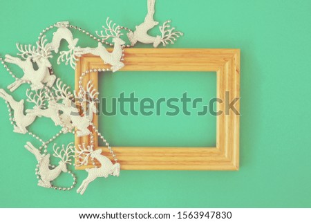 White glitter reindeer on green pastel paper background with texture of paper seen like grain film effects with space for text or image can write on. Christmas background with vintage style.