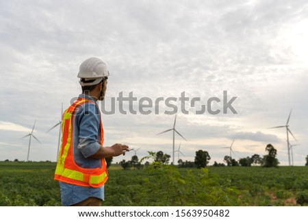 Picture of asian male electrical engineer working at wind turbine power generator station