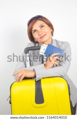 Happy beautiful business woman with passport and baggage going on a trip. Vacation and entertainment. Search for places to travel.
