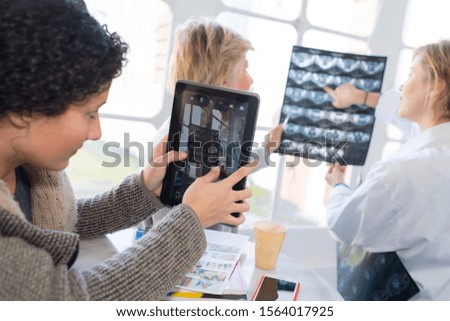 medical staff looking at xrays and tablet screen