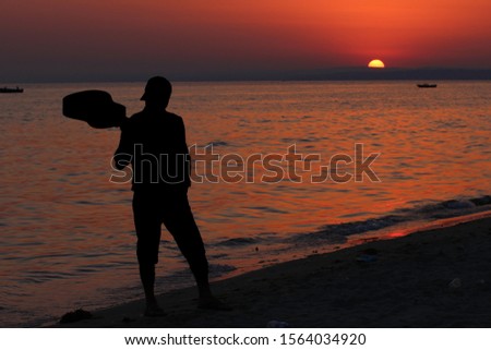 Man with guitar in hands at sunset