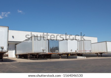 Semi box trailers on dock station. Royalty-Free Stock Photo #1564046530