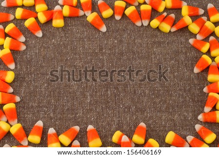 Candy Corn Framing Brown Tweed Fabric with center background space or room for your words, text, copy for Harvest Festival, Halloween or Thanksgiving