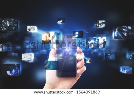 Hand holding smartphone with digital pictures on blurry dark background. Media photo gallery background. Multiexposure