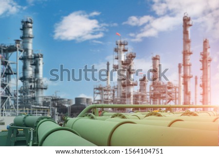 Steel long pipe in crude oil factory, pipe line transportation is most mammon way of transporting goods such as oil, natural gas or water on long distance,  pipe line in refinery plant background Royalty-Free Stock Photo #1564104751