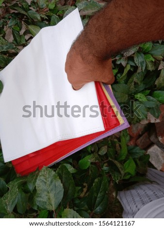 amazing D Cut Non woven Carry and Shopping Reusable Colored Bags, Grocery Bags Hanging on Hands, Eco friendly Bags on Green Plant