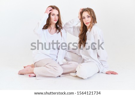two girls in white clothes on a white background in a photo Studio
