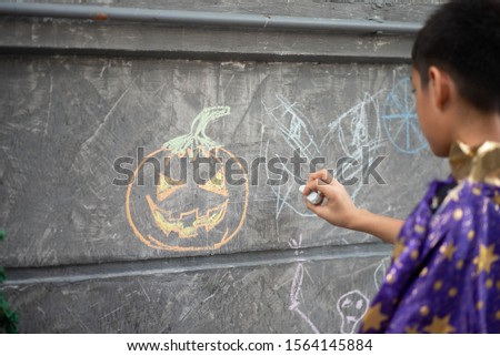 Kid drawing on the wall halloween theme by chalk