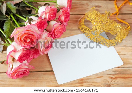 beautiful pink roses bunch, carnival mask and empty white blank on wooden background, Venice carnival concept