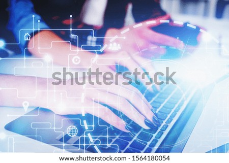 Businesswoman typing on laptop and businessman holding smartphone in blurry office with double exposure of big data interface. Toned image