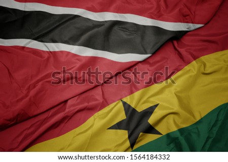 waving colorful flag of ghana and national flag of trinidad and tobago. macro