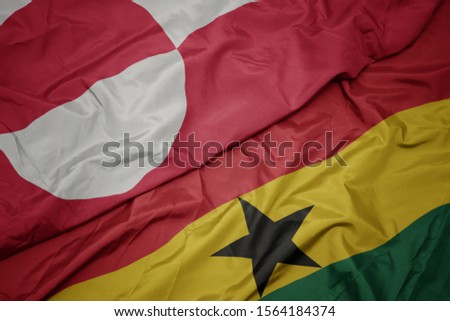 waving colorful flag of ghana and national flag of greenland. macro
