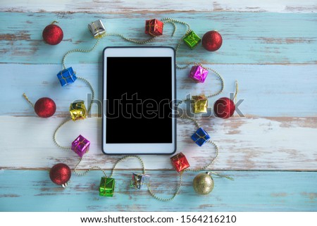Digital tablet and gift box on wooden background. View from above