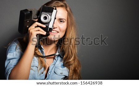 Smiling photographer woman taking pictures with old camera