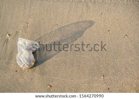 Plastic disposable cup on the beach in the sand. Ecological disaster and environmental pollution. Garbage on the beach. Harm to nature.serious damage to the environment, world pollution.