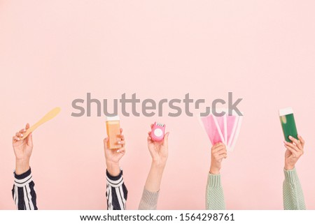 Female hands with supplies for hair removing on color background