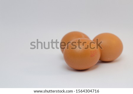 A close up picture of three eggs over the white background arranged neatly