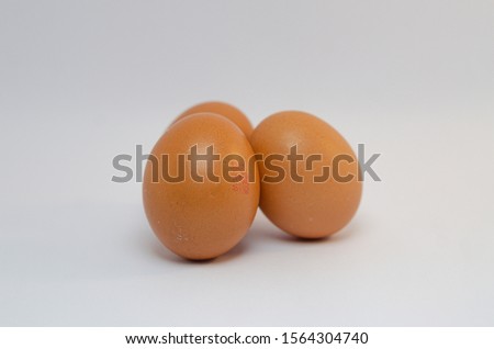 A close up picture of three eggs over the white background arranged neatly