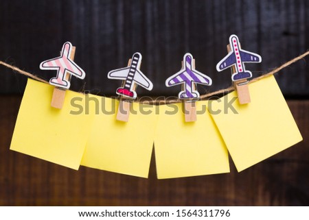 wooden clothespin with little airplanes holding empty paper notes for copy space on a wooden background ornaments decorative creative idea travel destinations 
