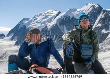 High altitude sickness. Climber holds his head because of headache. Royalty-Free Stock Photo #1564326769