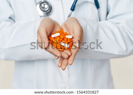 multi-colored pills in the hands of a doctor in a medical coat