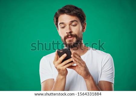 handsome man with mobile phones green background cropped view
